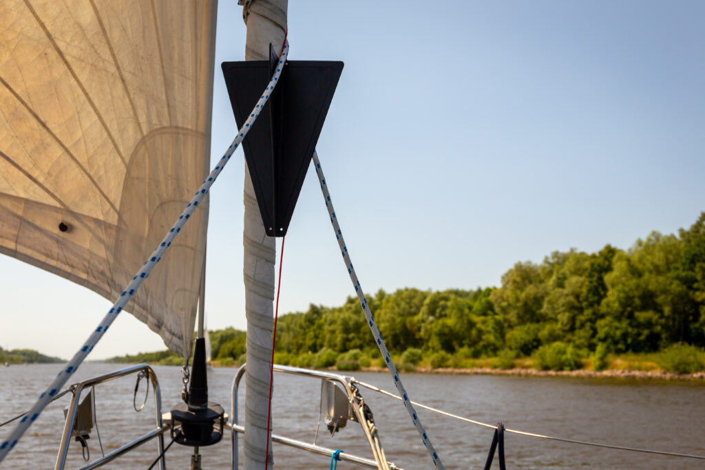 Black cone sign displayed on a sailing boat in Kiel Canal